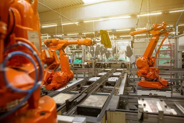 Brazos robóticos en una línea de producción industrial